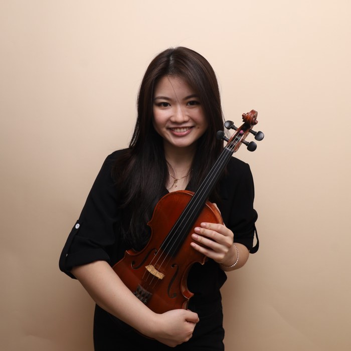 Xin Jie Cheong, Head Violin Teacher, holding her violin