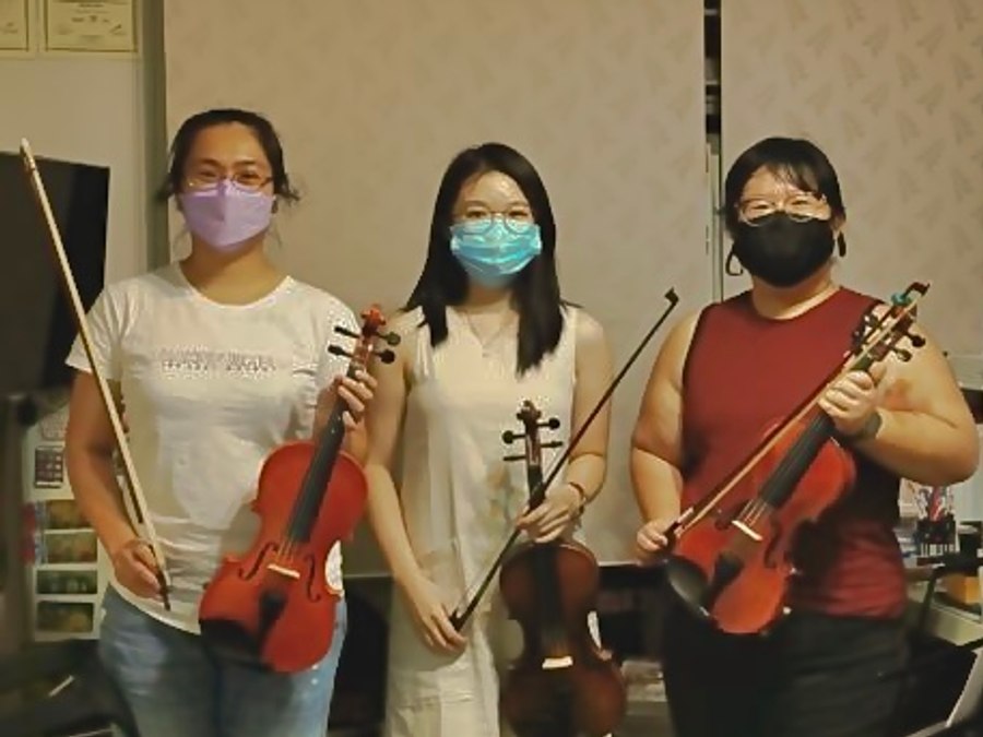 Three adult violin students after a group class
